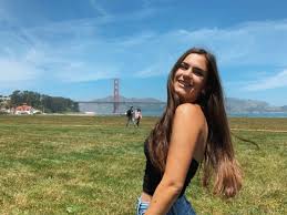 a woman standing in a field with a frisbee in her hand