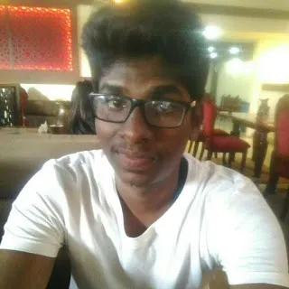 a man wearing glasses sitting at a table