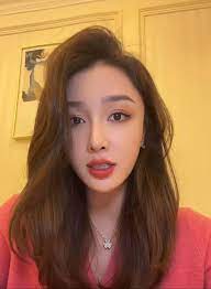 a woman with long brown hair is looking at the camera